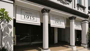 The entrance of Hotel 1915 with large signage, columns, and a motorbike parked outside. - Hotel 1915 Kuala Lumpur (Kuala Lumpur)