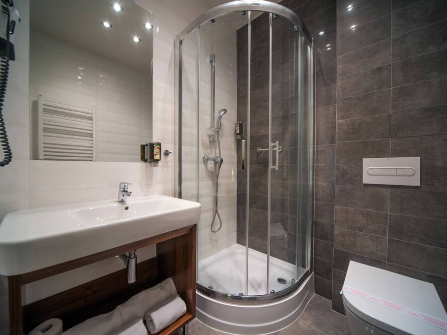 Une salle de bain moderne avec une douche à parois de verre, un lavabo blanc et des toilettes.