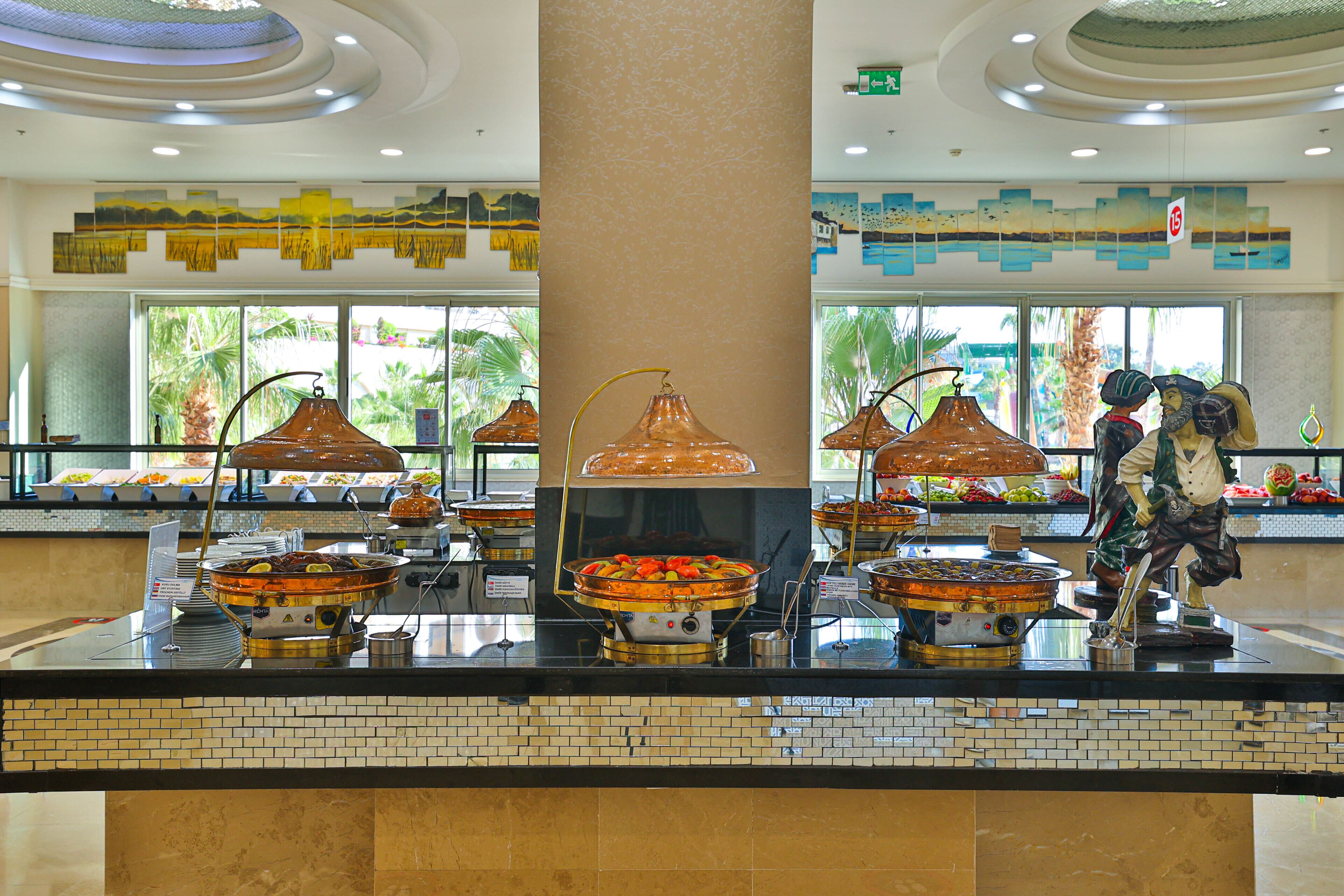 A buffet area with various food stations, a central column, and decorative lamps.