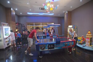 Un espacio interior bien iluminado con una mesa de hockey y juegos de arcade.