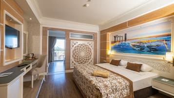 Habitación de hotel con cama, escritorio, silla, televisor y un cuadro en la pared.