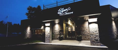 Un ristorante con facciata in pietra e insegna che riporta la scritta 'Le Canon Restaurant'.