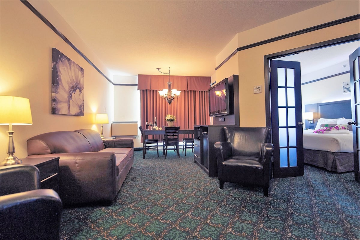 Suite, 1 cama King size, hidromasaje | Área de sala de estar | Televisión de pantalla plana y películas con cargo