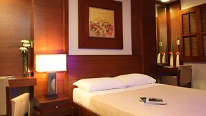 Habitación de hotel con cama, mesita de noche, lámpara y un cuadro en la pared.