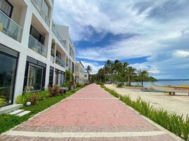 Un sendero que lleva a una playa, con un hotel a la izquierda.