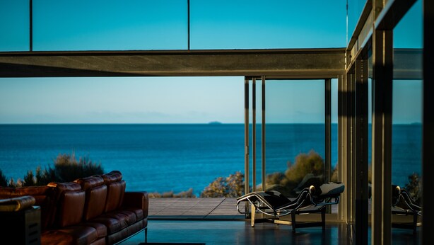 Une chambre moderne avec vue sur la mer, un canapé en cuir et un fauteuil de relaxation.
