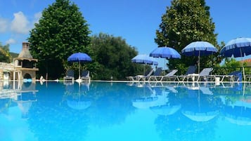 Een seizoensgebonden buitenzwembad, parasols voor strand/zwembad