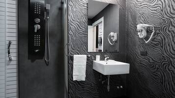 Ein modernes Badezimmer mit Dusche, Waschbecken und Handtuchhalter.