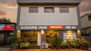 Une façade d’hôtel moderne avec l’inscription « Adore Inn » et l’enseigne « Fabexpress ».