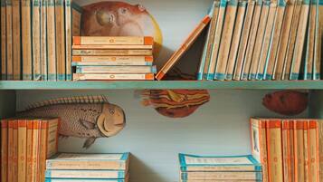 A bookshelf with books and decorative fish sculptures.