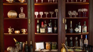 Un espace bar avec des étagères remplies de bouteilles d’alcool, de verres et un menu.