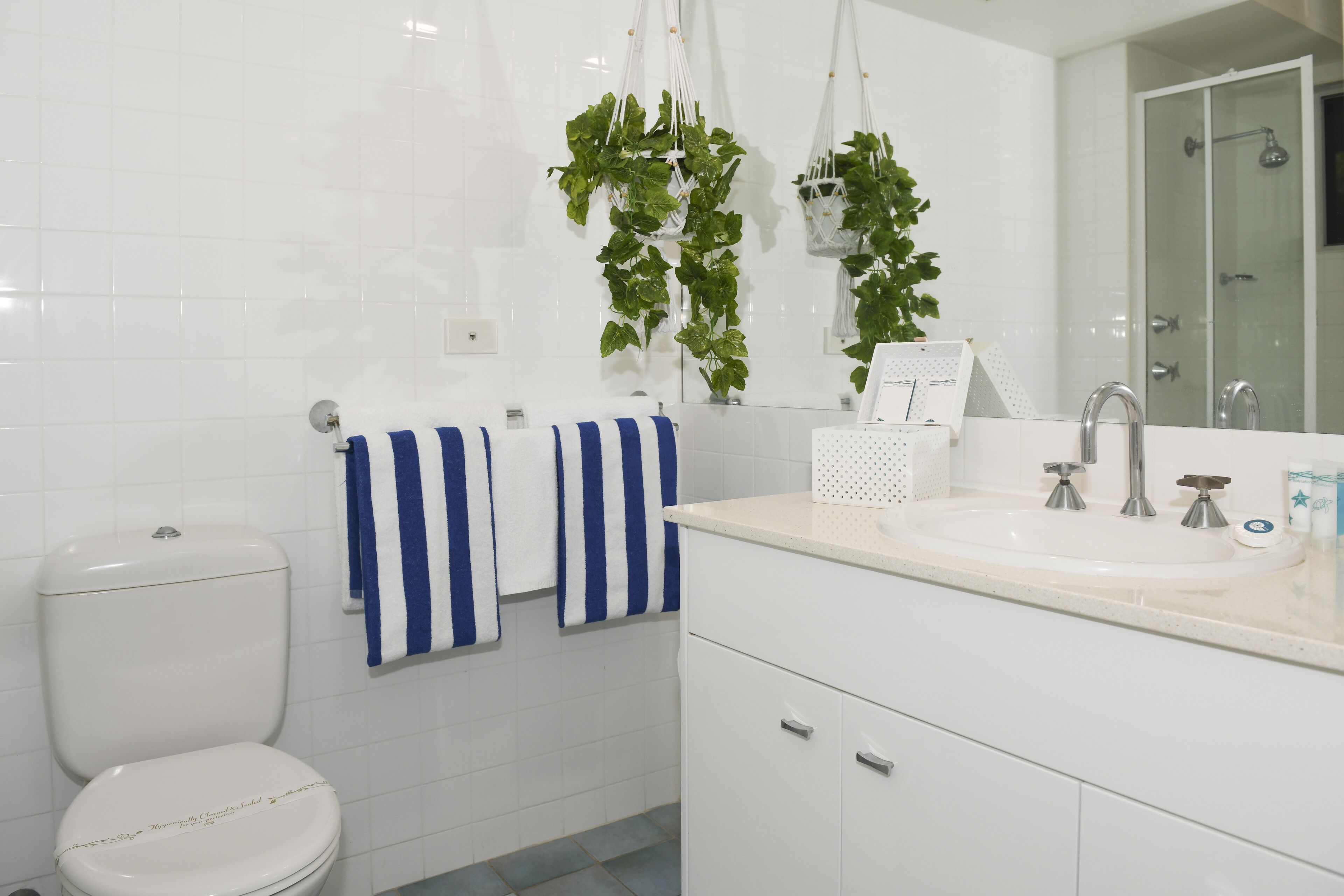 Een moderne badkamer met toilet, wastafel en douche.