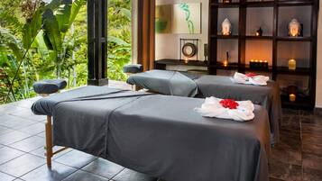 Experience relaxation in this serene spa room with two massage tables, a tranquil view, and soothing ambiance.