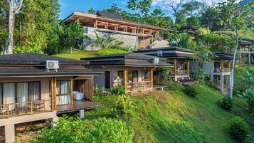 A resort with multiple guest villas, each featuring a balcony, a pool, and a view of the surrounding greenery.