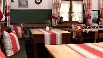 A traditional inn room with wooden furniture, plaid curtains, and a green wall.