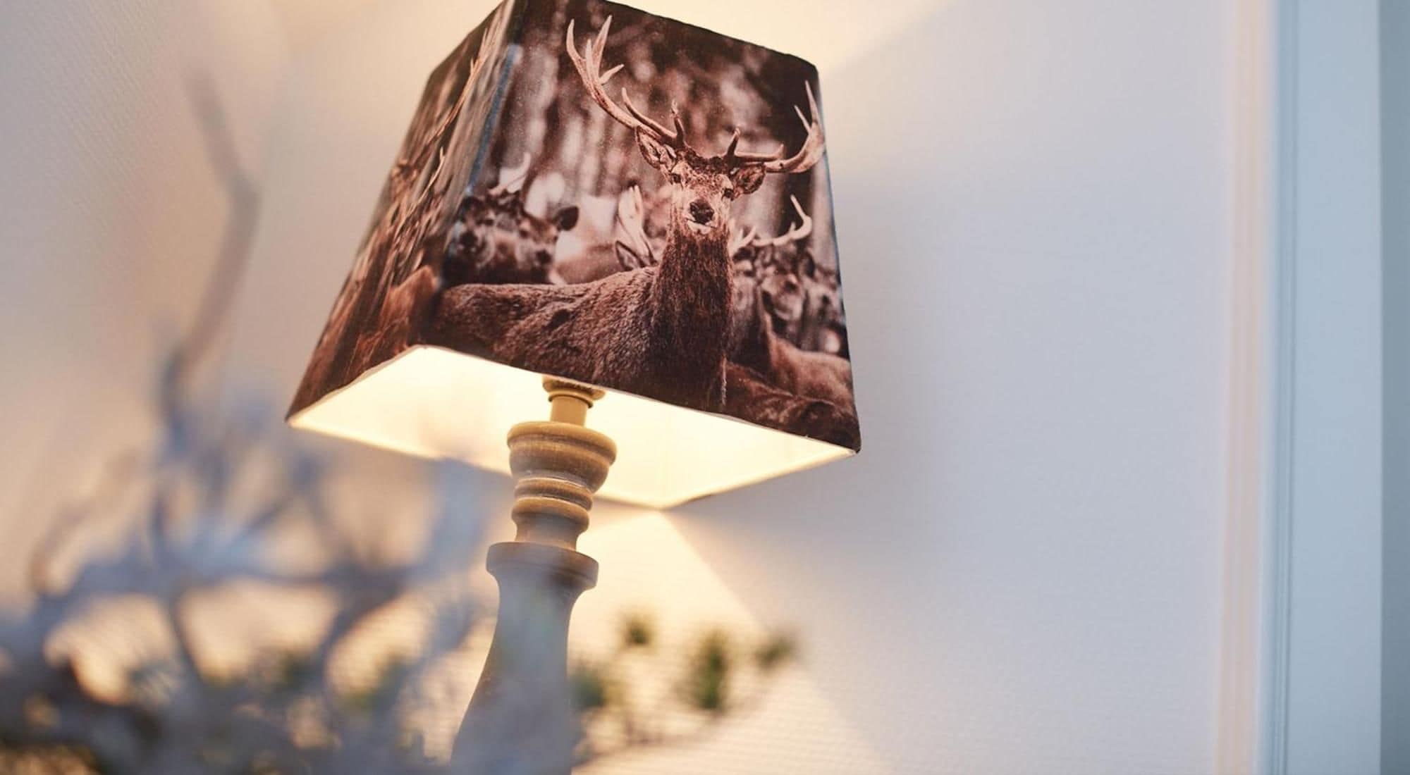 A lamp with a deer print shade.