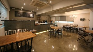 A spacious cafe with multiple seating areas, a chalkboard menu, and a modern design. - Won's Ville Myeongdong (Seoul)