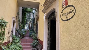 Um beco estreito que leva à entrada de um hotel com uma placa que diz "Casona de Vitrales Hotel".