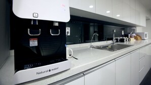 A modern kitchen with a water dispenser, a sink, and a coffee machine. - KSTAR Metro Hotel (Seoul)