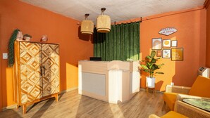 Une pièce avec un meuble en bois, un comptoir d’accueil et un rideau vert.