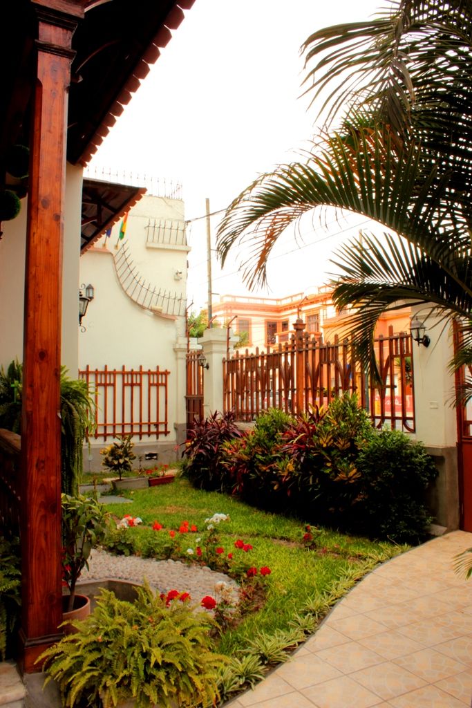 A courtyard with a wooden fence, potted plants, and a pathway.