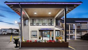 Een Days Inn hotel met een overdekte ingang, een parkeerplaats en een gebouw met een balkon.