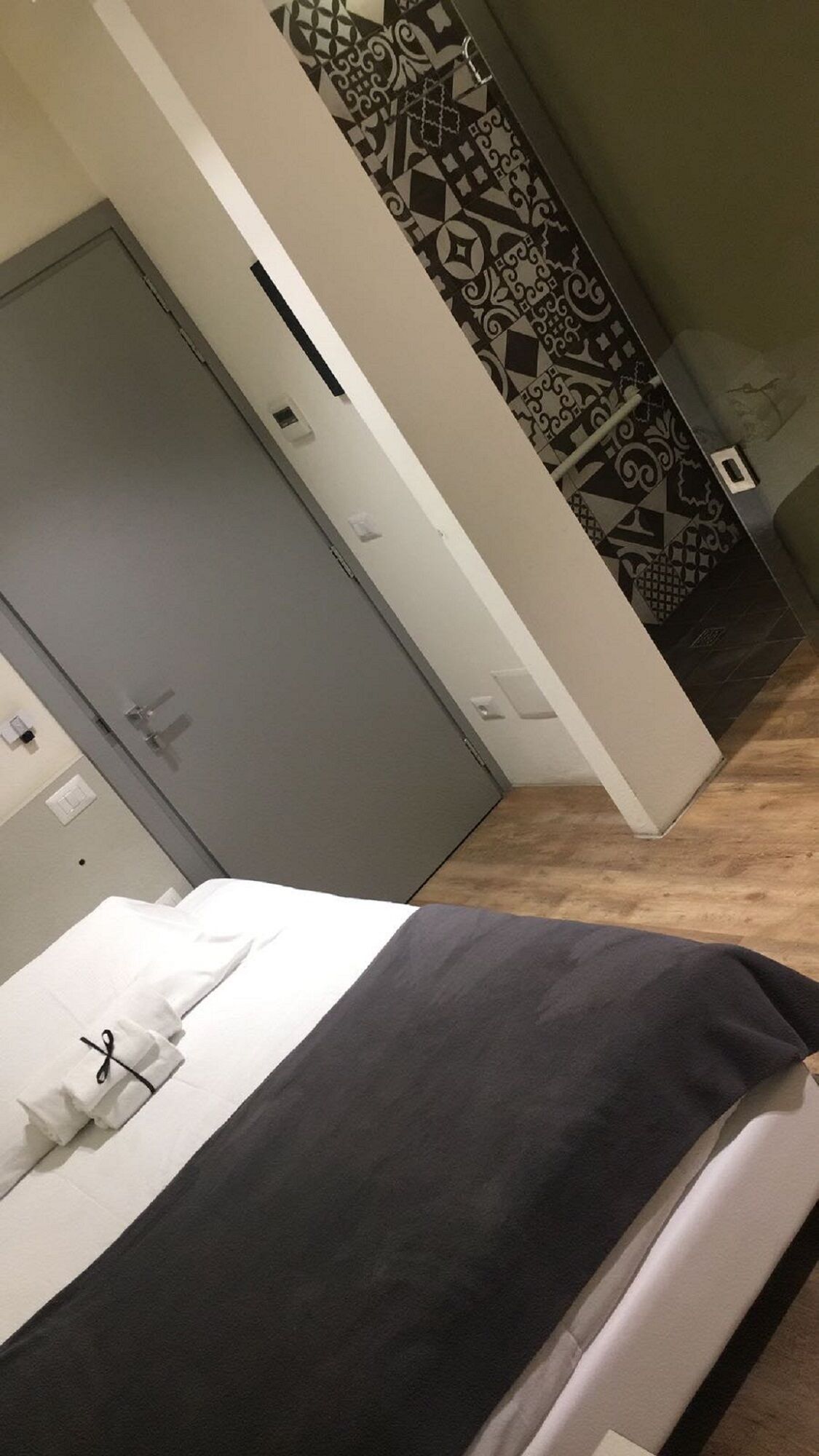 Una habitación con cama, armario y pared decorada.