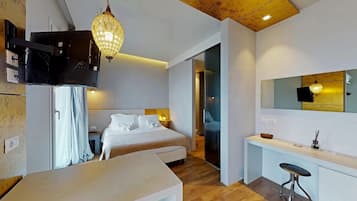 Una camera d'albergo moderna con un letto, un comodino, una scrivania e un ampio specchio.