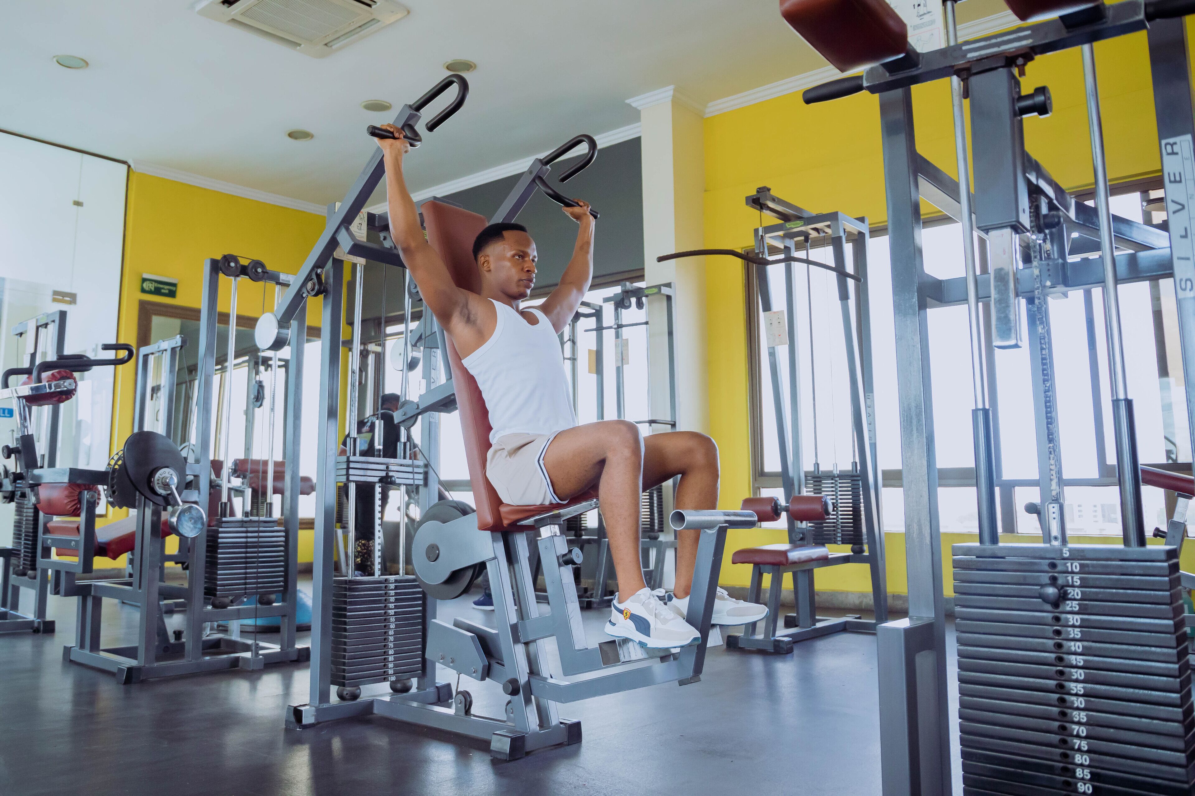 A gym with various exercise equipment, including a bench press and a cable machine.