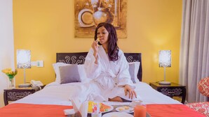 Una habitación de hotel con una cama, una bandeja con cosas para el desayuno y un cuadro en la pared.