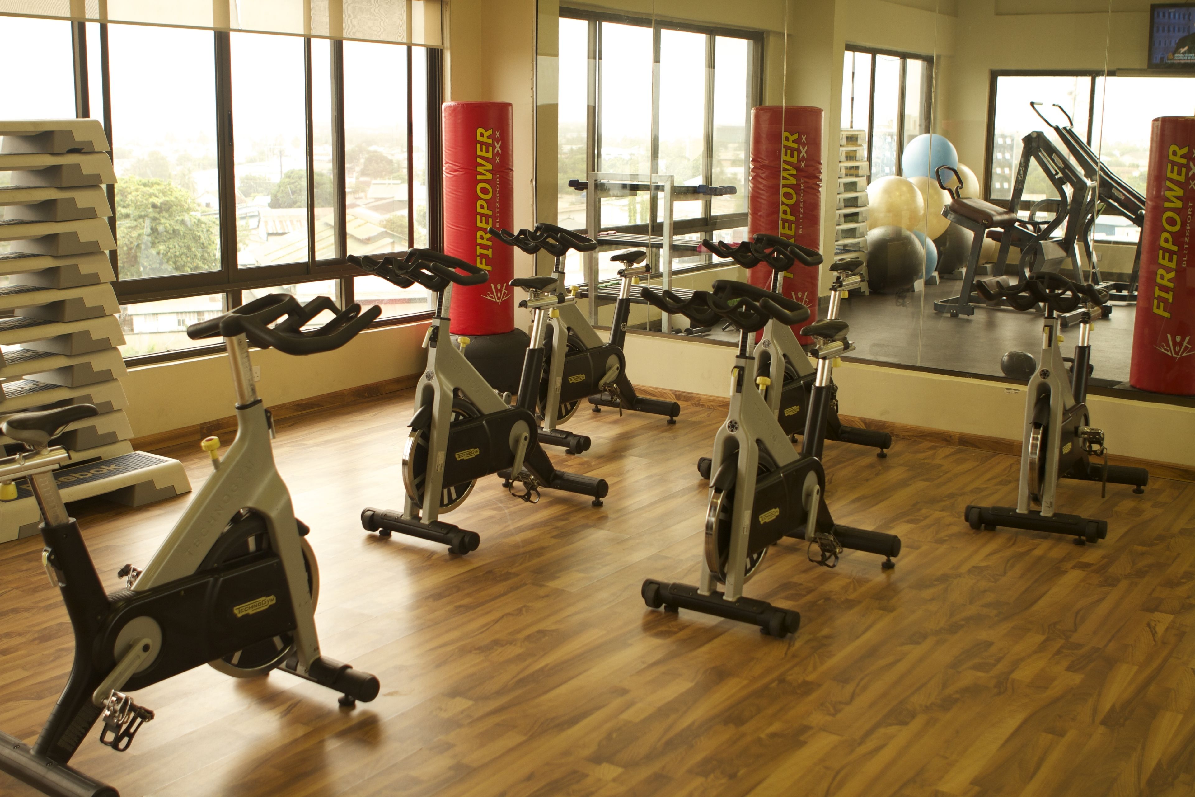 A gym with stationary bikes, exercise balls, and punching bags.