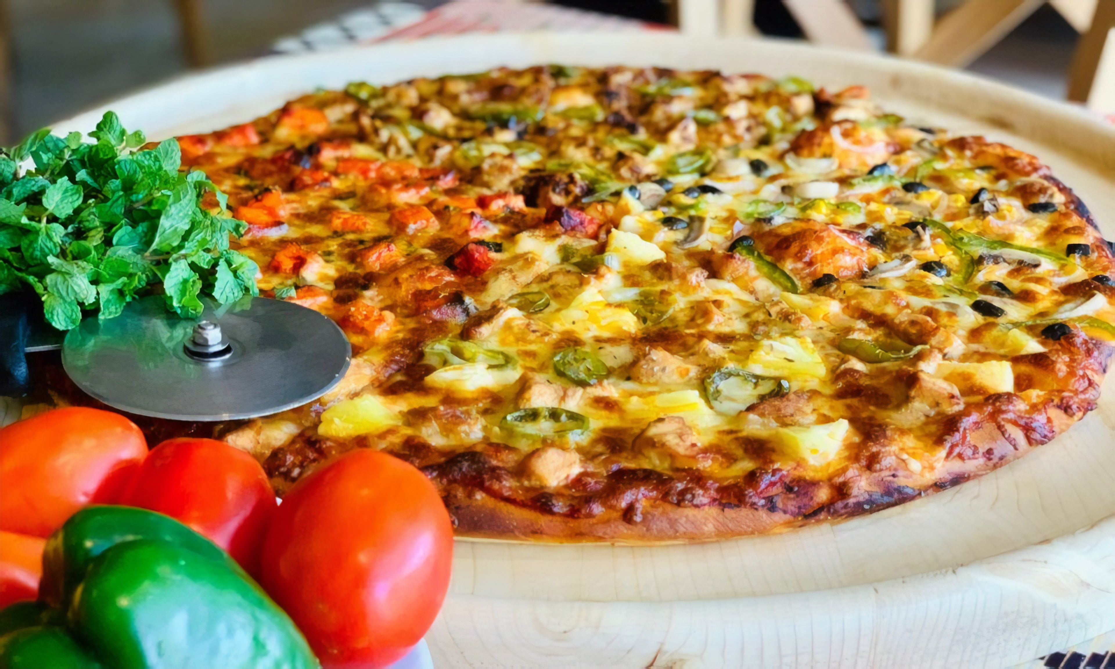 A pizza with various toppings on a wooden board.