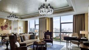 A spacious living room with a large window offering a city view, a chandelier, and a plush sofa. - Pullman Weifang (Weifang)