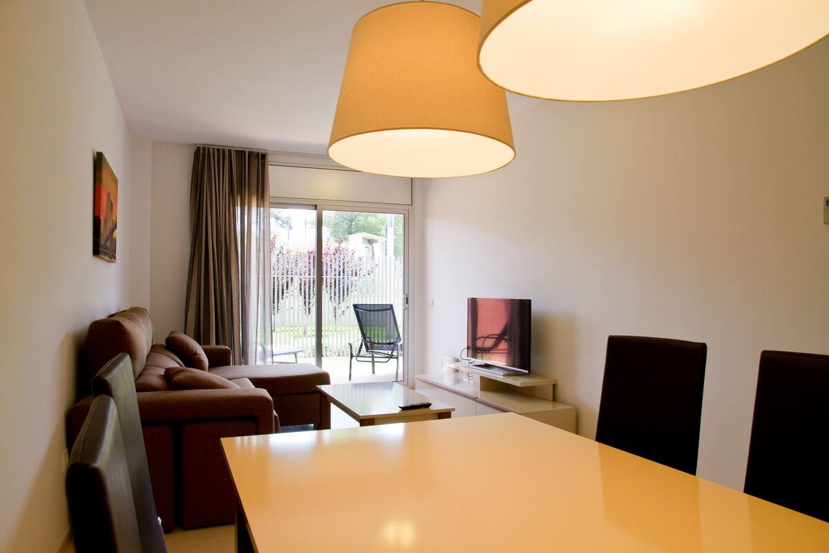 A modern living room with a sofa, a dining table, and a TV.