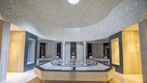 A spacious lobby with a central circular marble floor, tall columns, and a speckled ceiling. - Amelia Beach Resort Hotel & Spa (Manavgat)