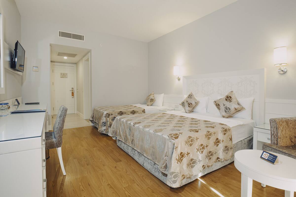 Een hotelkamer met twee bedden, een bureau en een stoel.