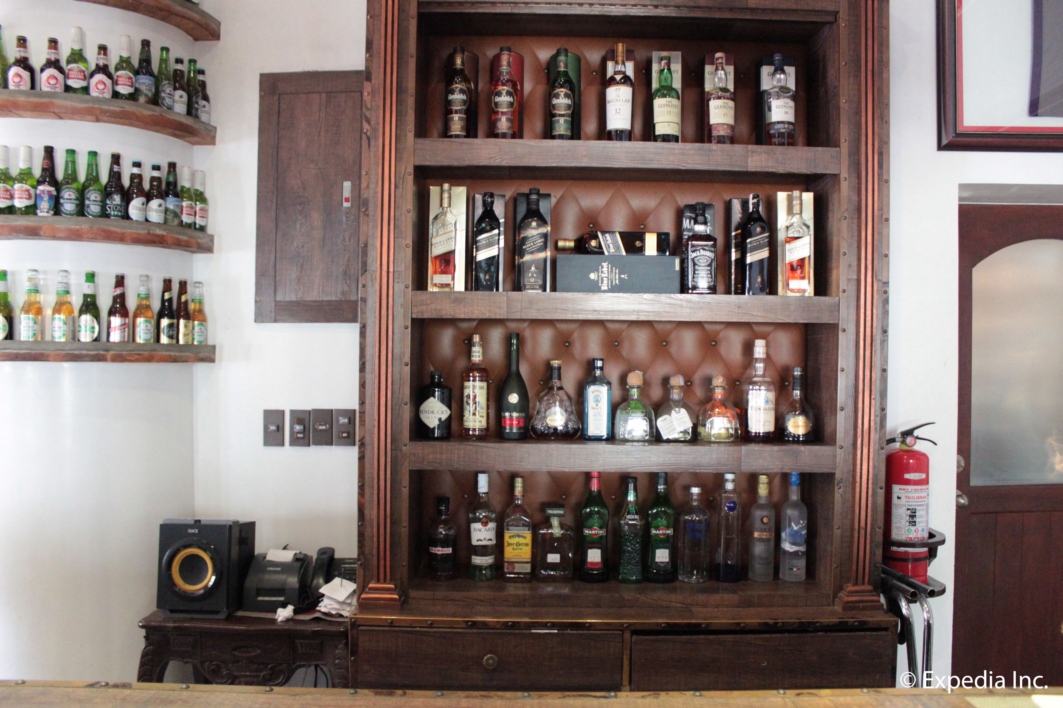 A liquor cabinet with multiple shelves of various bottles.