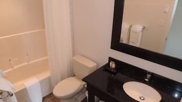 A bathroom with a bathtub, toilet, and sink.