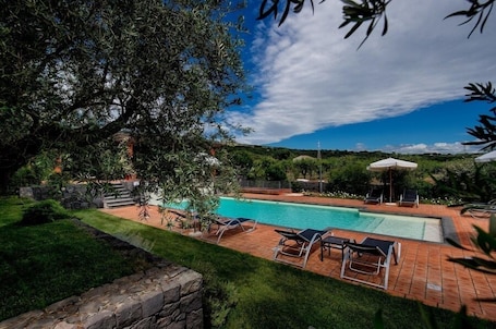 Una piscina al aire libre de temporada, sillones reclinables de piscina