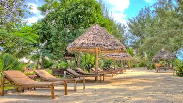 Plage, sable blanc, chaises longues, parasols