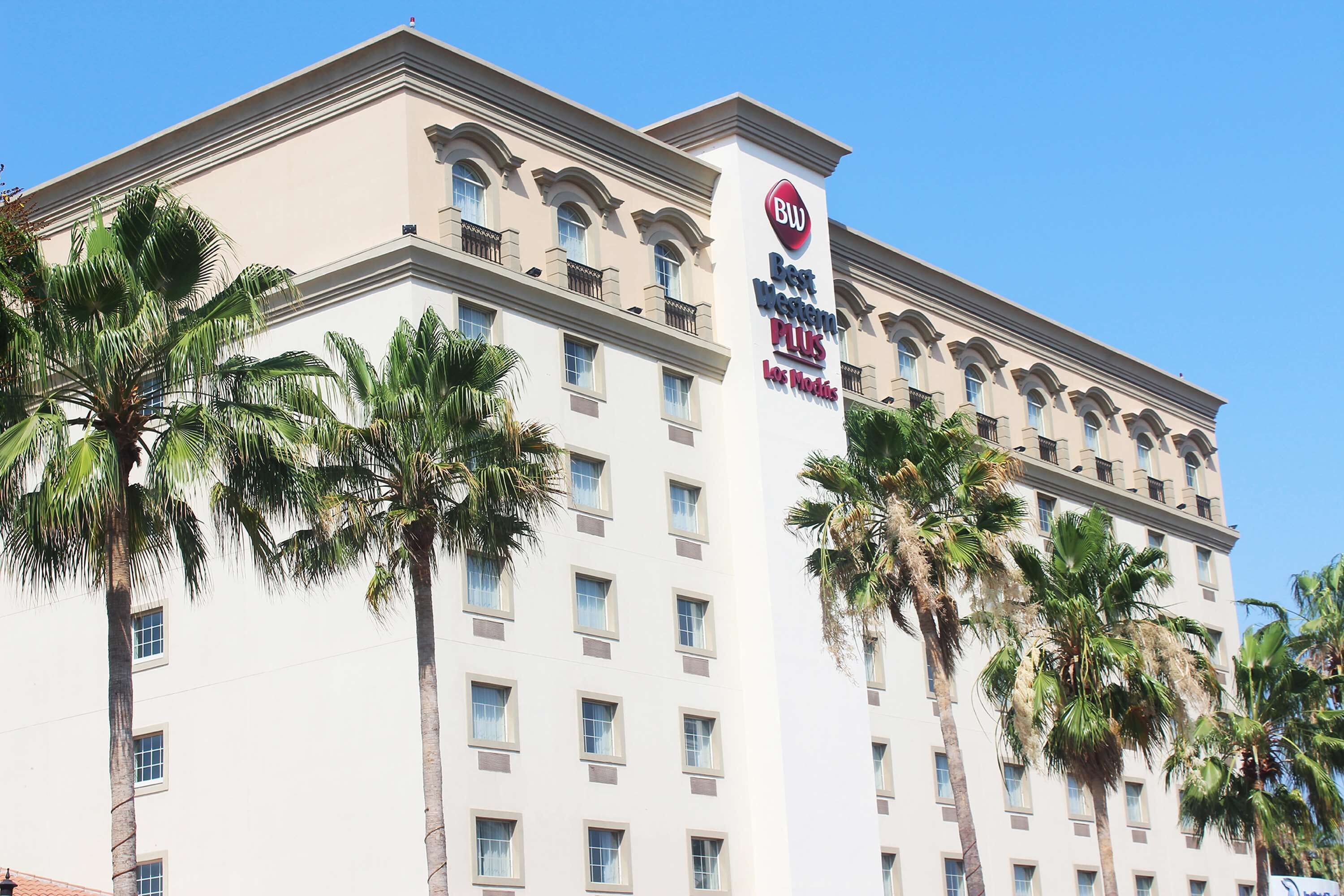 A multi-story hotel with a classic architectural design, featuring a prominent sign for Best Western Plus Los Angeles.
