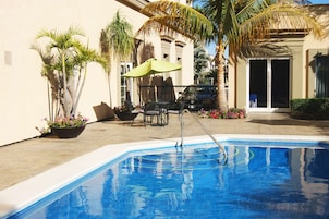 Una piscina al aire libre, sillones reclinables de piscina