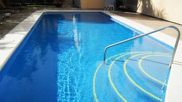 Alberca al aire libre y camastros