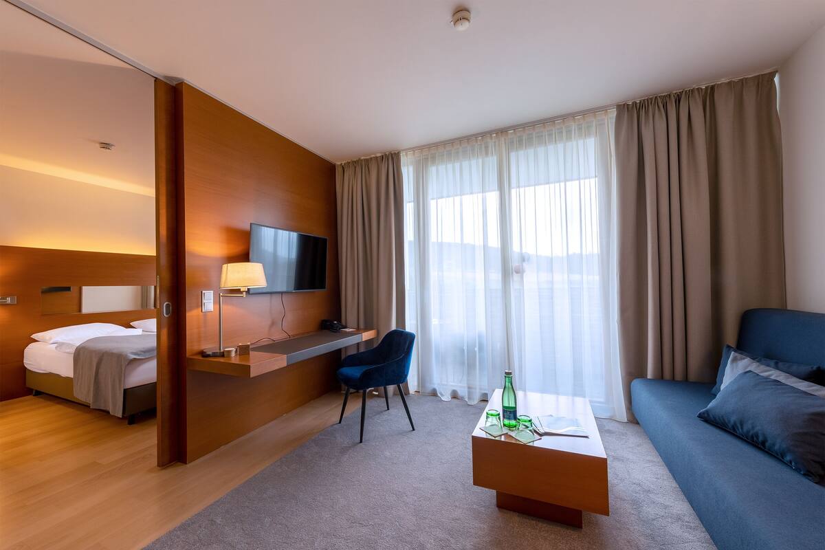 Een moderne hotelkamer met een bed, bureau en bank.