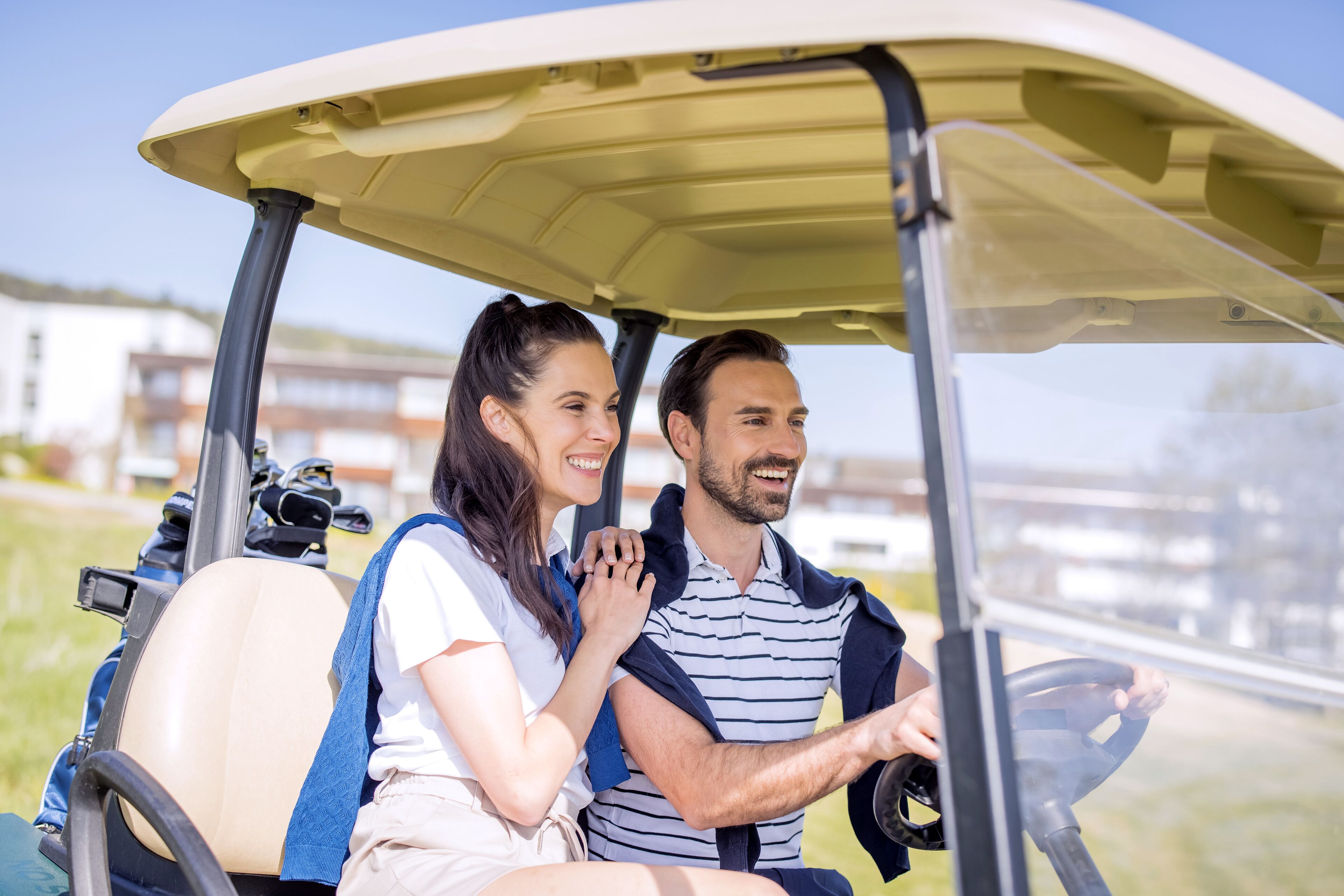 A golf cart with a driver and a passenger.
