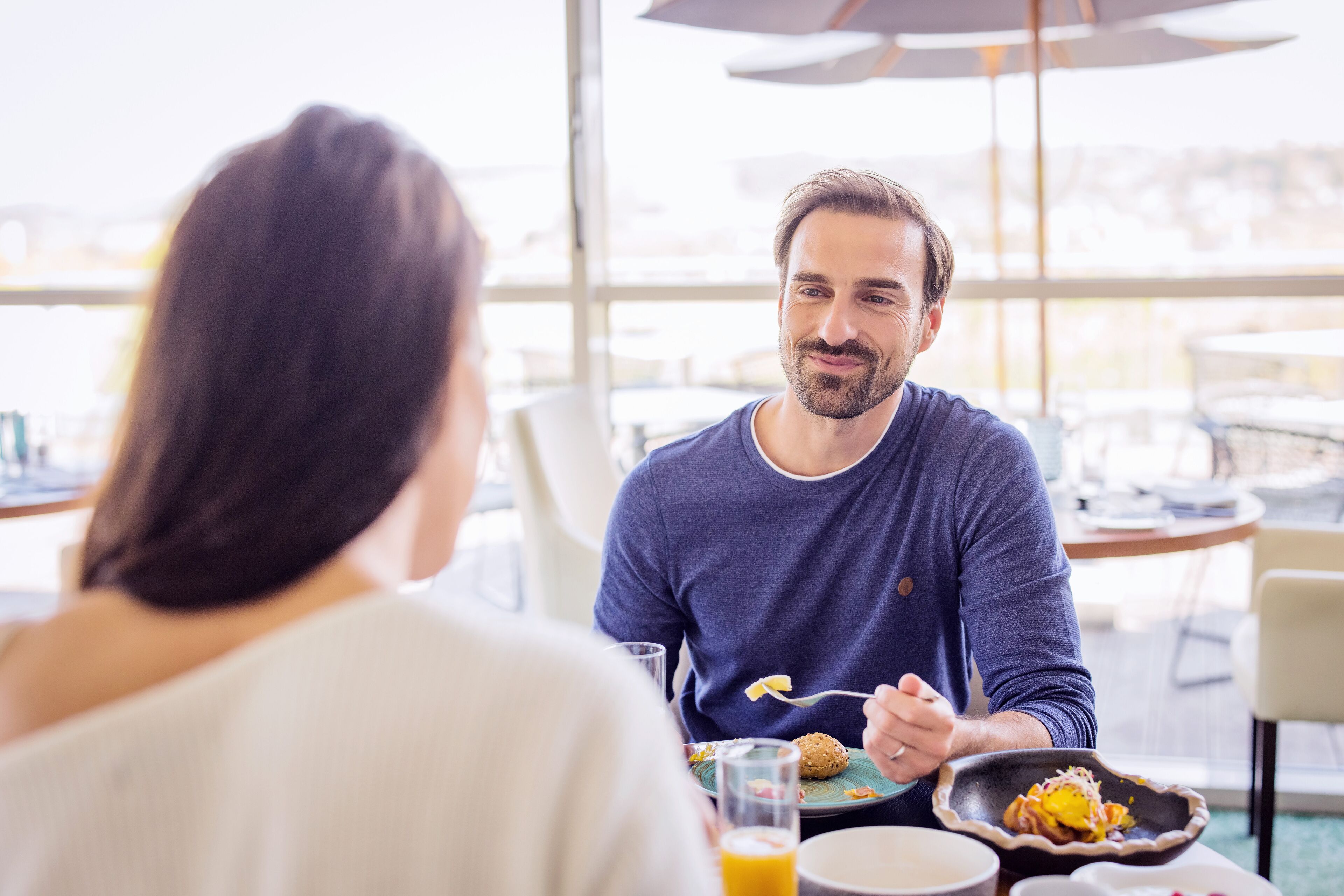 A dining area with a table set for two, a window with a view, and a casual dining atmosphere.
