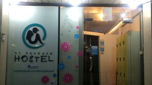 A hostel entrance with a glass door, a sign for 'At Phangan Hostel', and a sign indicating 'Guest Entry Only'. - At Phangan Hostel (Ko Pha-ngan)