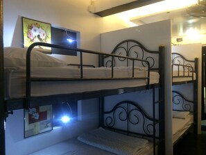 A bunk bed room with a framed picture on the wall and a ceiling light. - At Phangan Hostel (Ko Pha-ngan)