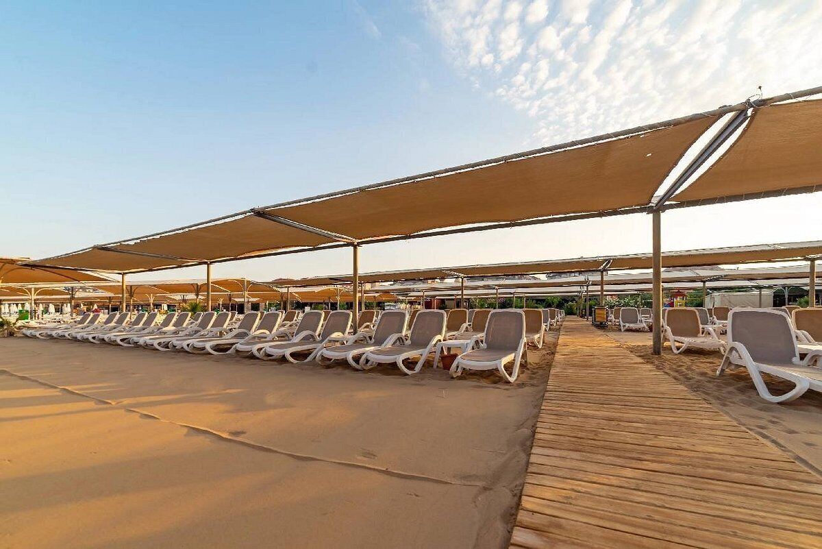 Ein Strandbereich mit Liegestühlen und Sonnenschirmen.