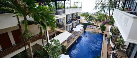 Una piscina al aire libre, sombrillas, tumbonas